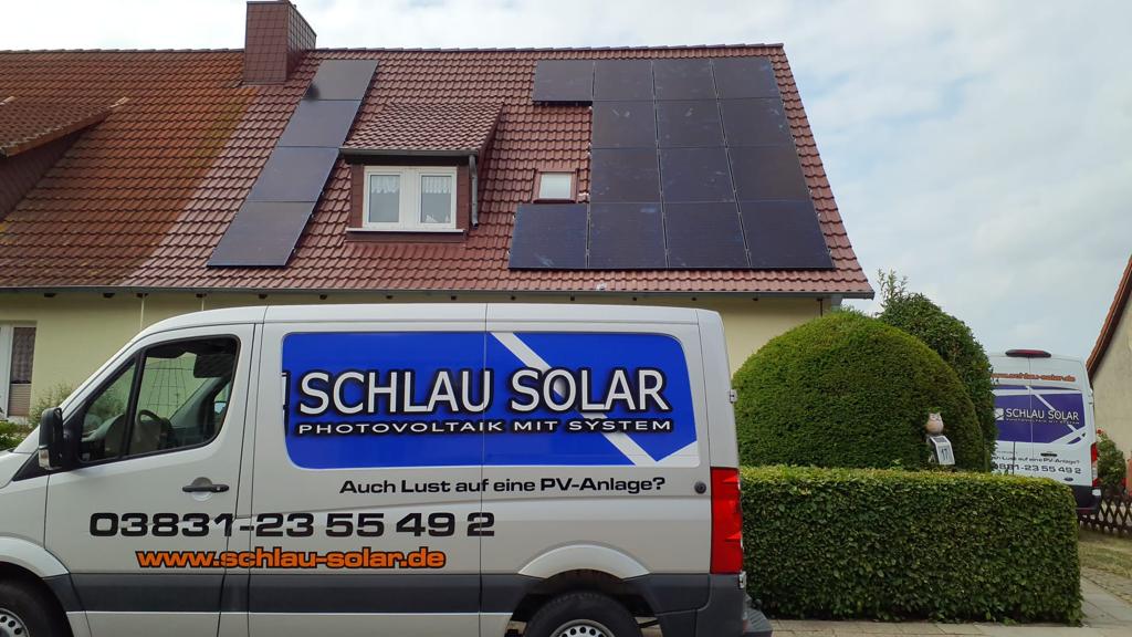 Unser Transporter für Photovoltaik Montage und Beratung in Neubrandenburg vor einem Haus mit Logo und Telefonnummer Schlau Solar GmbH.